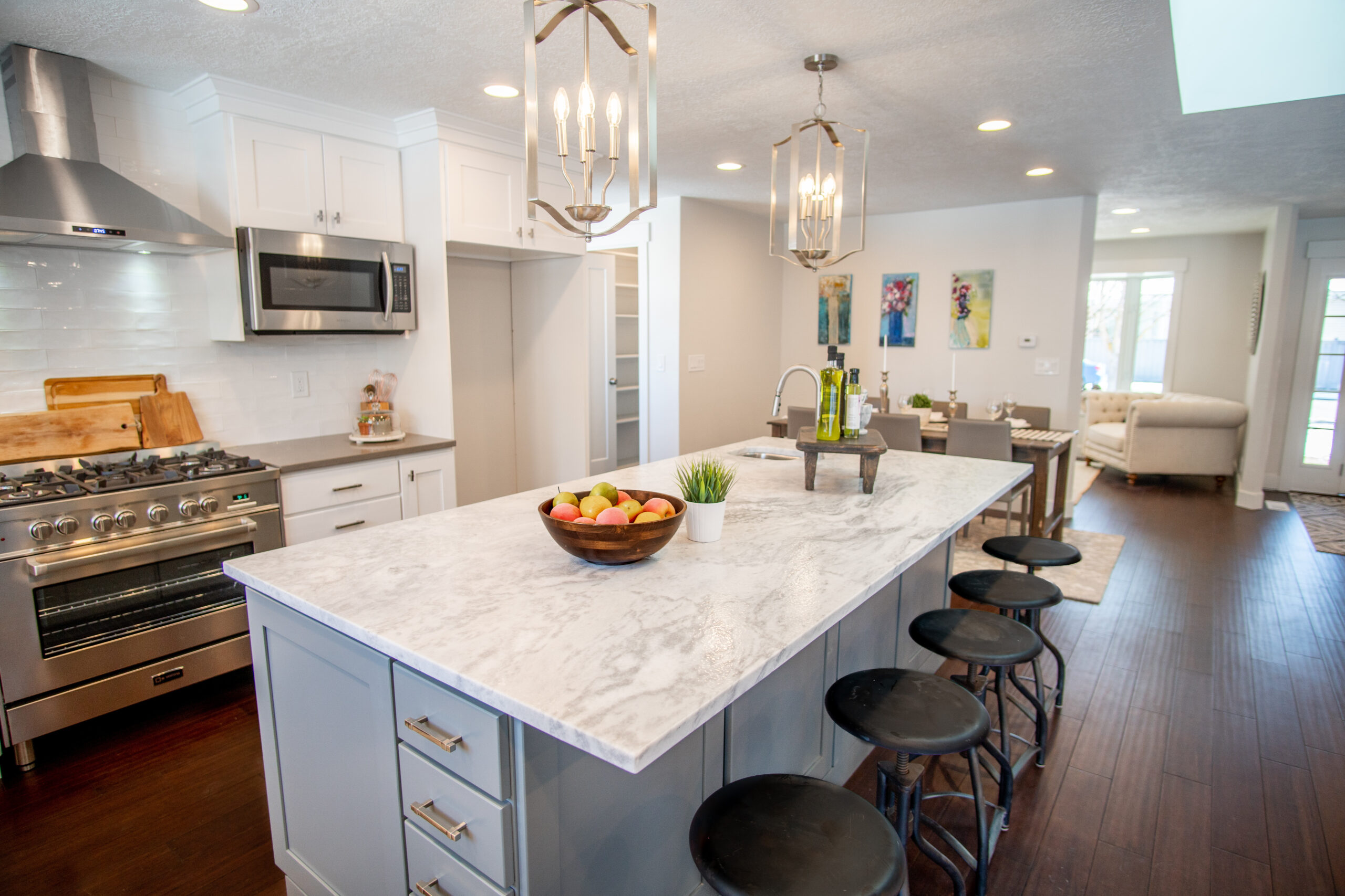 Modern kitchen with white cabinets, marble countertops, and pendant lighting designed by AHI Builders