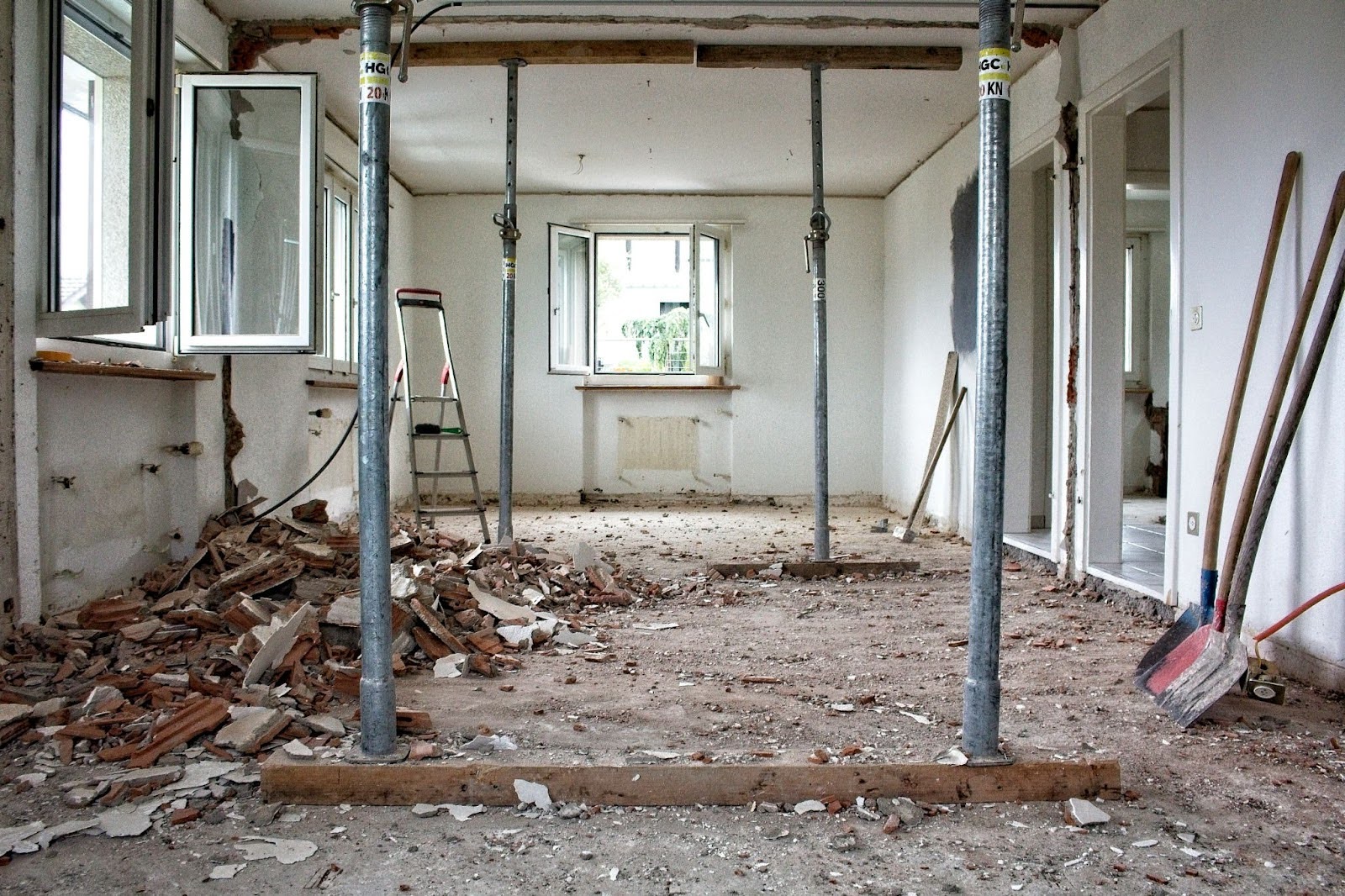 photo of an interior home remodel with walls and floors removed and debris and tools left inside