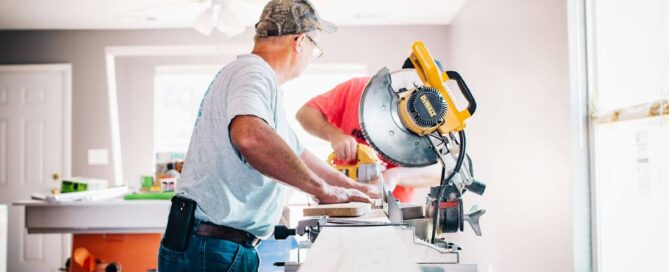 photo-of-two-contractors-using-saws-and-other-machinery