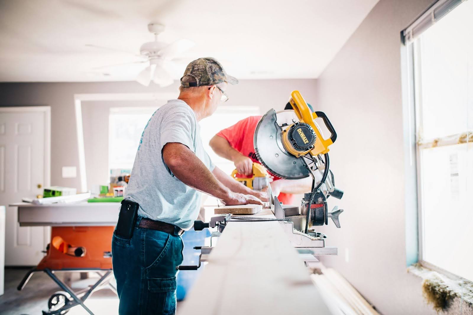 photo of two contractors using saws and other machinery to demonstrate the difference between remodeling and renovation
